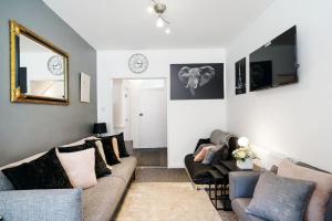 a living room with a couch and a mirror at 2 Bed Garden Flat Sleeps 6 Close to Brixton in London