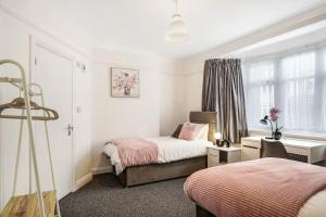 a bedroom with two beds and a desk and a window at 2 Bed Garden Flat Sleeps 6 Close to Brixton in London