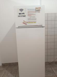 einen weißen Kühlschrank mit einem Schild darüber in der Unterkunft VASO'S APPARTMENTS A in Mesolongi