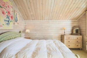 - une chambre avec un lit blanc et un plafond en bois dans l'établissement Les Chalets de Flaine Hameau - maeva Home - Chalet Pièces - Sélection 56, à Flaine