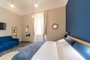 ein Schlafzimmer mit einem großen Bett und einer blauen Wand in der Unterkunft Porto Trani Maison D' Hòtes in Trani