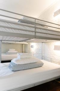 2 Etagenbetten in einem Schlafzimmer mit weißen Wänden in der Unterkunft Saintlo Ottawa Jail Hostel in Ottawa