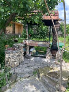 ogród z kamiennym kominkiem i domem w obiekcie Parsamyan's Art and Craft house w mieście Tekher