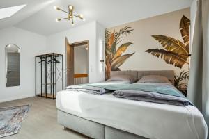 a bedroom with a large bed with a plant mural on the wall at NEU! Design-FeWo Heidetraum in Bad Fallingbostel