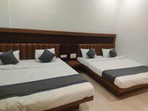 duas camas num quarto de hotel com saias em Hotel Nandan em Shegaon