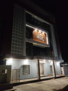 um sinal na lateral de um edifício à noite em Hotel Nandan em Shegaon