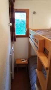 ein kleines Zimmer mit einem Etagenbett und einem Tisch in der Unterkunft Les Chalets D'arrondaz - 3 Pièces pour 6 Personnes 38 in Modane