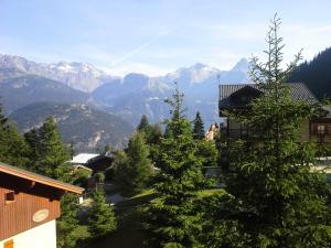 Blick auf eine Bergkette mit Bäumen und Gebäuden in der Unterkunft Les Chalets D'arrondaz - 3 Pièces pour 6 Personnes 38 in Modane