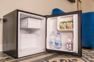 einen offenen Kühlschrank mit Wasserflaschen und Milch in der Unterkunft Porto Trani Maison D' Hòtes in Trani