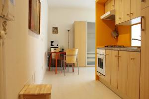 une cuisine avec une table et une cuisine aux murs jaunes dans l'établissement Appartamento Levante, à Bologne