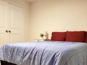 ein Schlafzimmer mit einem Bett mit einem roten Kissen in der Unterkunft Luxury Private Room 2 In Austin's Mckinney Falls in Austin