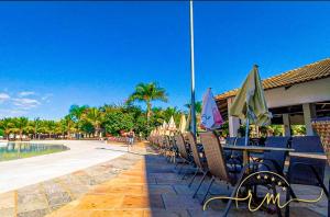 - une rangée de chaises et de tables avec parasols à côté de la piscine dans l'établissement Lacqua diRoma RM Hospedagem, à Caldas Novas