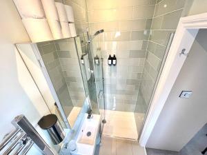 a shower with a glass door in a bathroom at Luxury King-bed Ensuite With Tranquil Garden Views in London +17 photos