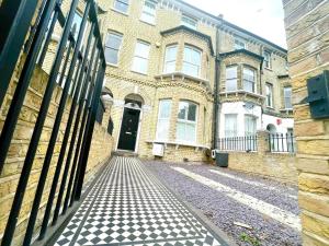 a brick building with a black door and a street at Luxury King-bed Ensuite With Tranquil Garden Views in London