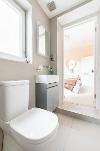 a bathroom with a toilet and a sink and a bedroom at Luxury King-bed Ensuite With Quiet Private Patio in London