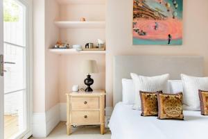 1 dormitorio con cama blanca y almohadas en Luxury King-bed Ensuite With Quiet Private Patio, en Londres