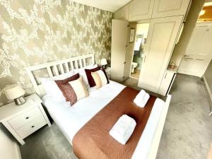- une chambre dotée d'un grand lit avec des draps et des oreillers blancs dans l'établissement Luxury King-bed Ensuite With Tranquil Garden Views, à Londres