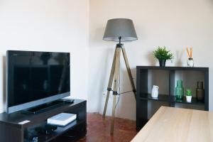 um candeeiro numa sala de estar com uma televisão de ecrã plano em Prêcheurs furnished flat em Aix-en-Provence