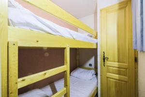 2 stapelbedden in een kleine kamer met een deur bij Résidence Arche - maeva Home - Appartement 2 Pièces 6 Personnes - Confort 96 in Arâches-la-Frasse