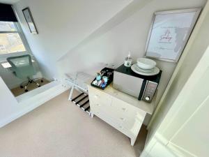 uma pequena cozinha com um micro-ondas e uma cadeira em Bright Quiet Loft Room Ensuite Serene Clapham Area em Londres