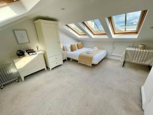 a attic bedroom with a bed and skylights at Bright Quiet Loft Room Ensuite Serene Clapham Area in London