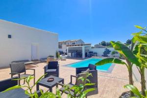 een achtertuin met een zwembad en stoelen en een huis bij Villa 3 chambres avec piscine in Saint-Laurent-dʼAigouze