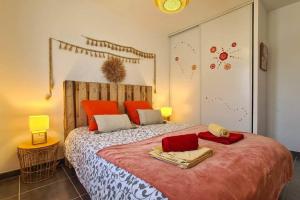 - une chambre avec un grand lit et des oreillers orange dans l'établissement Villa 3 chambres avec piscine, à Saint-Laurent-dʼAigouze