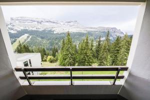 una finestra con panchina affacciata sulle montagne di Résidence Arche - maeva Home - Studio 4 Personnes - Confort 97 ad Arâches