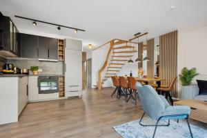 uma cozinha em plano aberto e sala de estar com mesa de jantar e cadeiras em NEU! Design-FeWo Heidetraum em Bad Fallingbostel