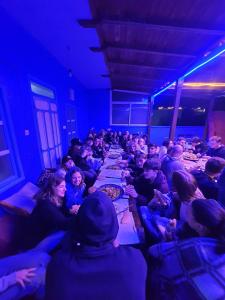 a group of people sitting at long tables in a room at Hostel Aline in Chefchaouen