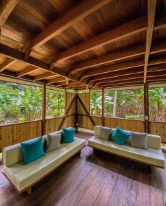 a living room with two couches with blue pillows at Casa Prana, Termales, Nuqui in Nuquí
