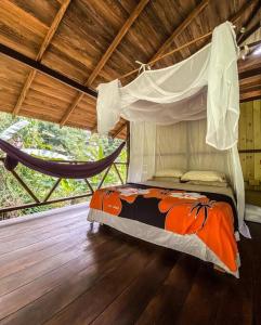 a bed in a room with a hammock at Casa Prana, Termales, Nuqui in Nuquí