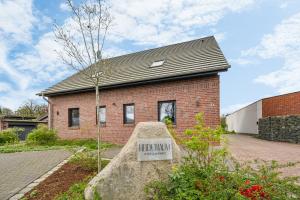 a brick house with a sign in front of it at NEU! Design-FeWo Heidetraum in Bad Fallingbostel