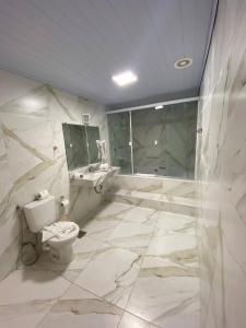 uma casa de banho com um WC, um lavatório e um chuveiro em Pousada Kaliman Premium em Campos do Jordão