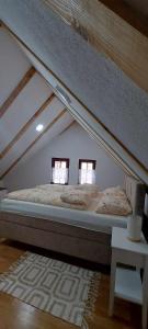 Una cama en una habitación abuhardillada con dos ventanas. en Villa Ruža Vareš, en Vareš