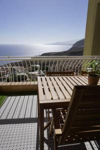 a wooden table and bench on a balcony with the ocean at Sea La Vie Tabaiba - Piscina, Parking & Tenis in Tabaiba