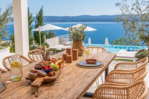 un tavolo in legno con un piatto di cibo sopra di Seaview villa Agata with heated infinity pool a Lokva Rogoznica