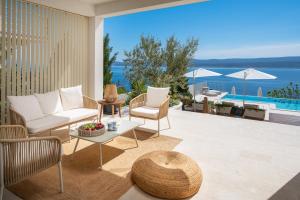 patio con sedie, tavolo e piscina di Seaview villa Agata with heated infinity pool a Lokva Rogoznica Altre 59 foto