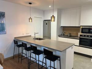 a kitchen with a large island with bar stools at Sea La Vie Tabaiba - Piscina, Parking & Tenis in Tabaiba