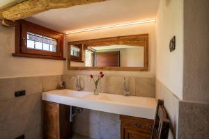 a bathroom with a sink with a vase of flowers at Baita Eleonora in Argegno