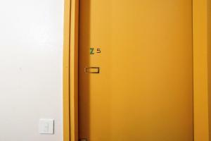 Eine gelbe Tür mit der Zahl der Siebzig drauf. in der Unterkunft Résidence Aldébaran - maeva Home - Studio 4 personnes - Confort 99 in Arâches-la-Frasse