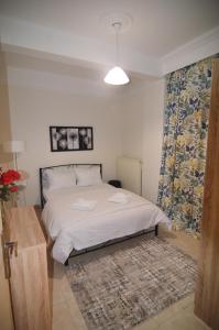 - une chambre avec un lit blanc et un tapis dans l'établissement Georgia's lakeside house, à Kastoria