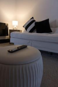 a living room with a couch and a remote control at 1 bedroom apartment - The Onyx in Cheltenham