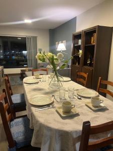 una mesa con platos y un jarrón de flores. en Gran Rivadavia en Ushuaia