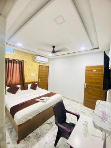 een slaapkamer met een bed, een bureau en een stoel bij Seven star in Indore