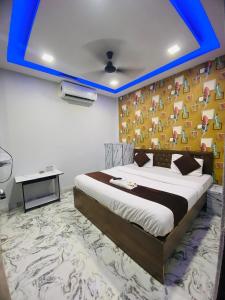 a bedroom with a large bed with a blue ceiling at Seven star in Indore