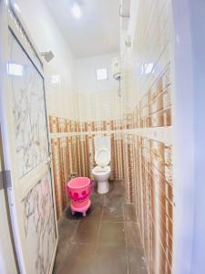 La salle de bains est pourvue de toilettes et d'une baignoire rose. dans l'établissement Seven star, à Indore