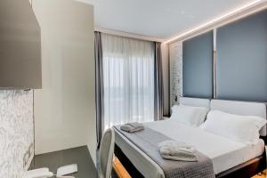 a bedroom with a bed and a window with towels on it at Hotel Due Mari & SPA in Rimini