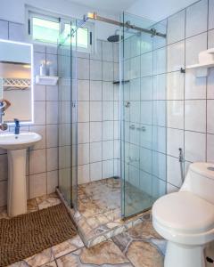 a bathroom with a shower with a toilet and a sink at BUDDA HOME in Tortuguero