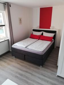クックスハーフェンにあるFerienwohnung-2-im-Sahlenburger-Ferienhausのベッドルーム1室(赤い枕2つ付きのベッド1台付)